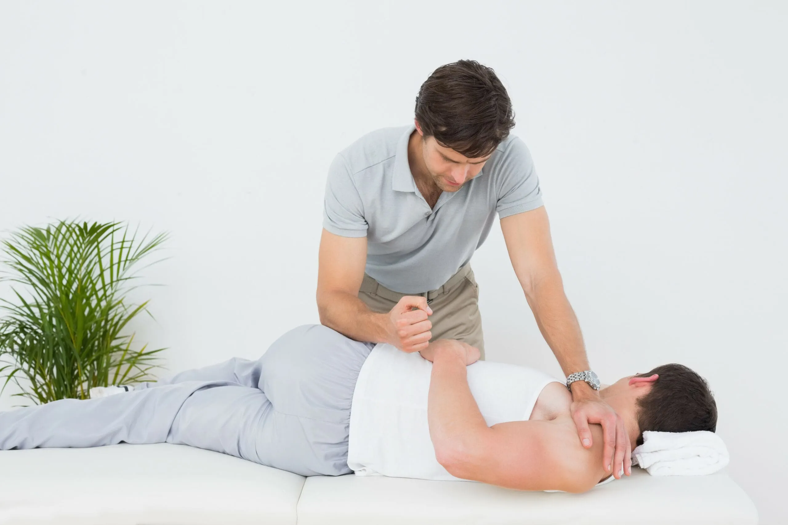 Male physiotherapist examining patient in the medical office Pain Relief Management in Albuquerque